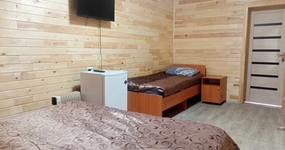 №2 (3 места) - 1 этаж. Одна односпальная кровать, одна двуспальная кровать, 3 тумбочки, холодильник, ТВ. Окна выходят на дровяной склад (август 2022).