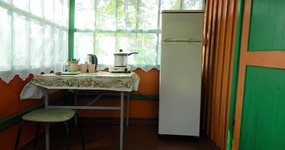 Кухонная зона на веранде: стол, стулья, холодитьник, плита, эл.чайник